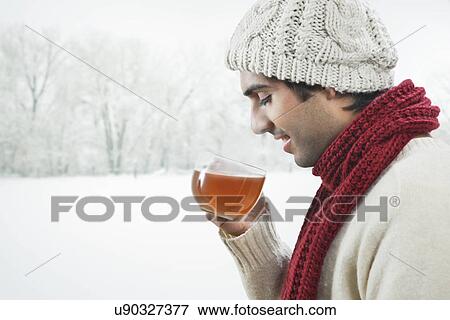 Young man drinking black tea during winter View Large Photo Image Stock Photo - Young man drinking black tea during winter . Fotosearch
