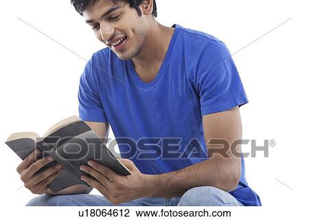 Young man enjoying reading book over white background View Large Photo Image Stock Image - Young man enjoying reading book over white background . Fotosearch