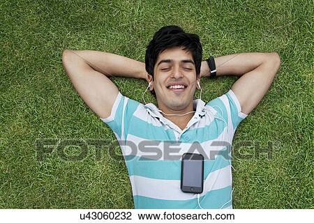 Stock Image - Young man listening to music . Fotosearch
