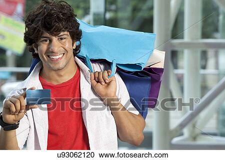 Young man showing his credit card for easy shopping View Large Photo Image Stock Image - Young man showing his credit card for easy shopping . Fotosearch