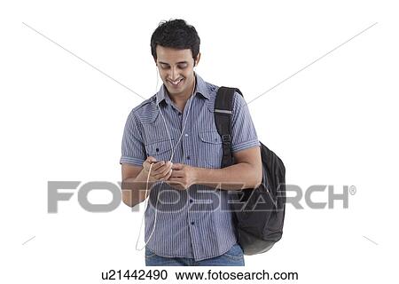 Stock Image - Young man smiling and listening to music . Fotosearch