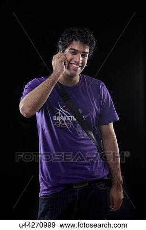 Young man talking on a mobile phone View Large Photo Image Stock Photo - Young man talking on a mobile phone . Fotosearch