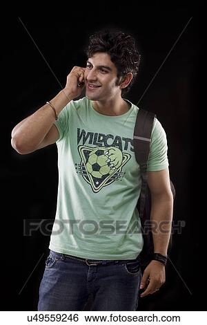 Young man talking on a mobile phone View Large Photo Image Stock Photograph - Young man talking on a mobile phone . Fotosearch