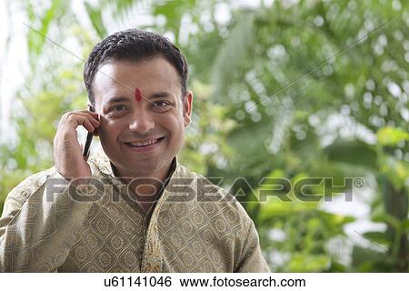 Stock Photograph - Young man talking on a mobile phone . Fotosearch