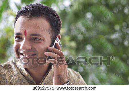 Young man talking on a mobile phone View Large Photo Image Stock Photography - Young man talking on a mobile phone . Fotosearch