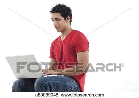 Young man using laptop over white background View Large Photo Image Stock Photography - Young man using laptop over white background . Fotosearch
