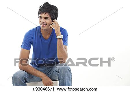 Stock Image - Young man using phone over white background . Fotosearch