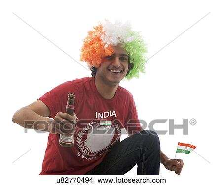 Picture - Young man with a wig holding a beer bottle . Fotosearch