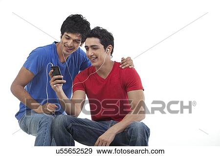 Young men listening to music on mobile over white background View Large Photo Image Stock Photo - Young men listening to music on mobile over white background . Fotosearch