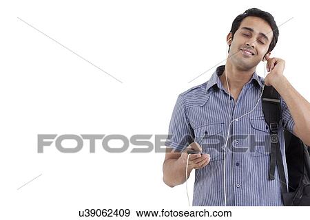 Young smiling man listening to music with eyes closed View Large Photo Image Stock Photo - Young smiling man listening to music with eyes closed . Fotosearch
