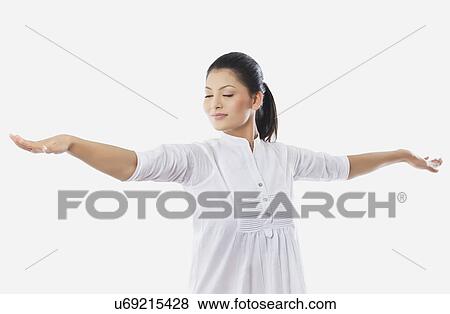 Young smiling woman with arms outstretched over white background View Large Photo Image Stock Photo - Young smiling woman with arms outstretched over white background . Fotosearch