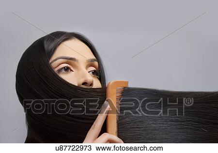 Young woman combing her beautiful long hair over colored background View Large Photo Image Stock Image - Young woman combing her beautiful long hair over colored background . Fotosearch
