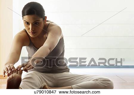 Stock Photo - Young woman doing stretching exercise. Fotosearch