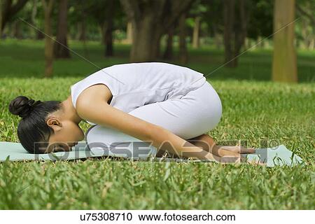 Young woman doing yoga on a lawn View Large Photo Image Stock Image - Young woman doing yoga on a lawn . Fotosearch