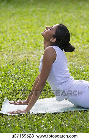 Stock Photo - Young woman doing yoga on a lawn . Fotosearch