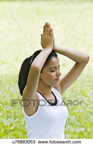 Stock Image - Young woman doing yoga with hands in prayer position . Fotosearch