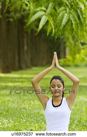Stock Photo - Young woman doing yoga with hands in prayer position . Fotosearch