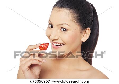 Young woman eating a strawberry View Large Photo Image Stock Photo - Young woman eating a strawberry . Fotosearch