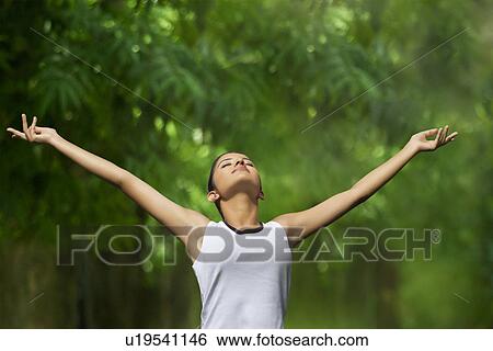 Young woman enjoying nature in a park View Large Photo Image Stock Photograph - Young woman enjoying nature in a park . Fotosearch
