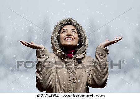 Picture - Young woman enjoying snow fall . Fotosearch