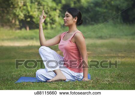 Stock Image - Young woman exercising in park . Fotosearch