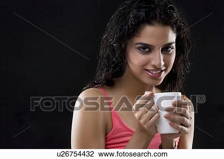 Stock Image - Young woman holding a mug . Fotosearch
