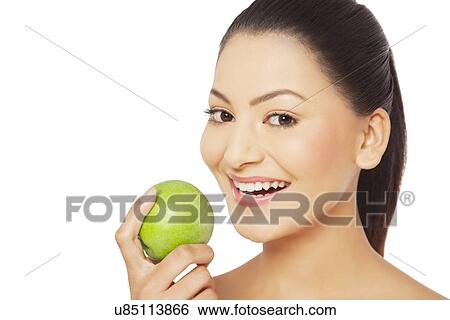 Young woman holding green apple over white background View Large Photo Image Stock Photograph - Young woman holding green apple over white background . Fotosearch