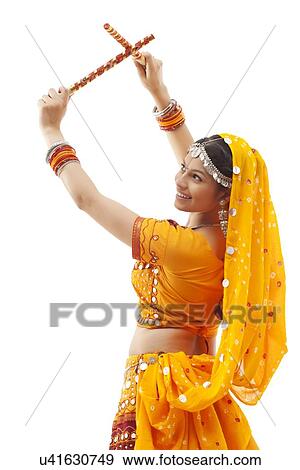 Young woman in chaniya choli performing Dandiya Raas over white background View Large Photo Image Stock Photo - Young woman in chaniya choli performing Dandiya Raas over white background. Fotosearch