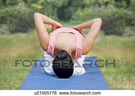 Young woman in lawn doing yoga View Large Photo Image Stock Photograph - Young woman in lawn doing yoga . Fotosearch