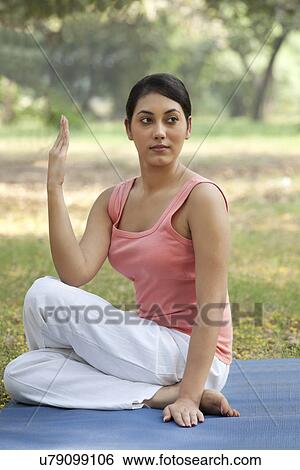 Stock Photograph - Young woman looking away while exercising . Fotosearch