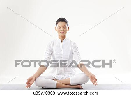 Stock Photo - Young woman meditating over white background . Fotosearch