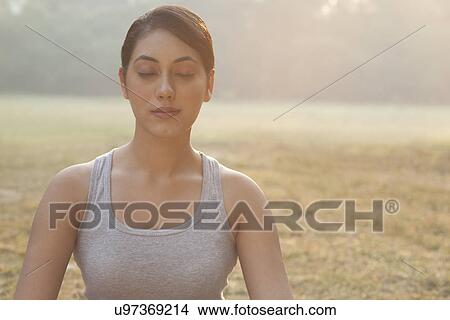 Picture - Young woman meditating . Fotosearch