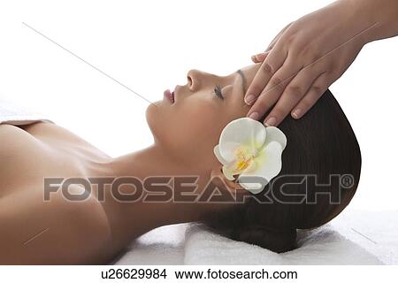 Picture - Young woman on massage table getting head massage . Fotosearch