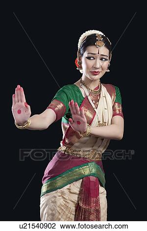 Young woman performing Bharatanatyam over black background View Large Photo Image Stock Image - Young woman performing Bharatanatyam over black background. Fotosearch