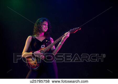 Young woman playing the guitar View Large Photo Image Stock Photo - Young woman playing the guitar . Fotosearch