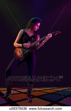 Stock Photograph - Young woman playing the guitar . Fotosearch
