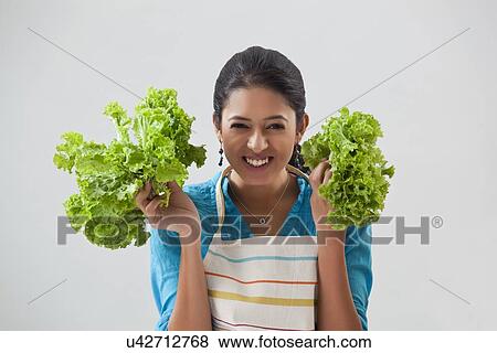 Young woman posing with bunches of lettuce View Large Photo Image Stock Photo - Young woman posing with bunches of lettuce. Fotosearch