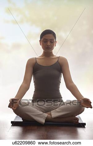 Young woman practicing yoga on mat View Large Photo Image Stock Image - Young woman practicing yoga on mat. Fotosearch