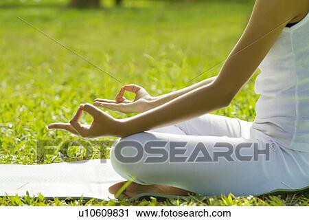 Young woman sitting in lotus position View Large Photo Image Stock Image - Young woman sitting in lotus position . Fotosearch