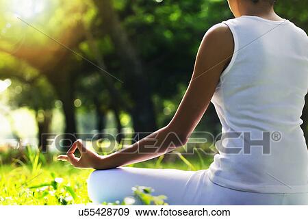 Stock Photo - Young woman sitting in lotus position . Fotosearch