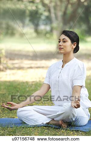 Stock Photo - Young woman sitting in lotus position . Fotosearch