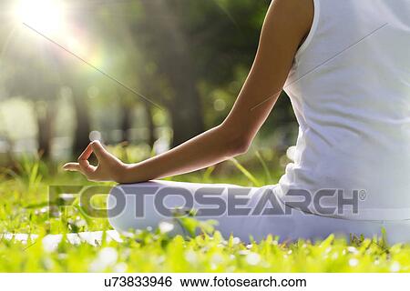 Young woman sitting in lotus position View Large Photo Image Stock Photograph - Young woman sitting in lotus position . Fotosearch