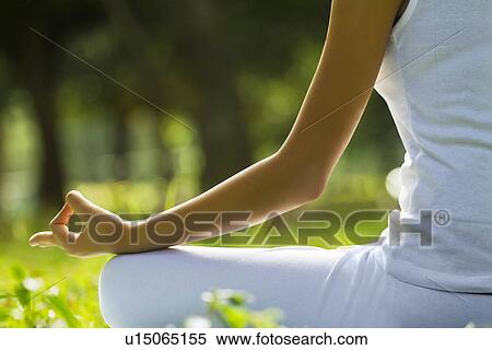 Stock Photography - Young woman sitting in lotus position . Fotosearch