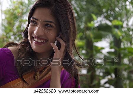 Stock Image - Young woman talking on a mobile phone . Fotosearch