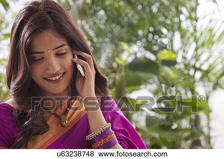 Young woman talking on a mobile phone View Large Photo Image Stock Photo - Young woman talking on a mobile phone . Fotosearch