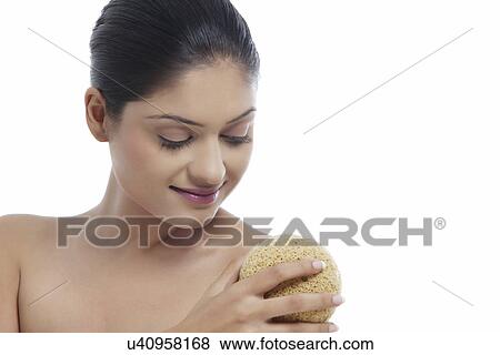 Stock Photo - Young woman using massage sponge . Fotosearch