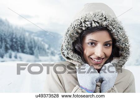 Stock Photo - Young woman wearing a hood outdoors . Fotosearch