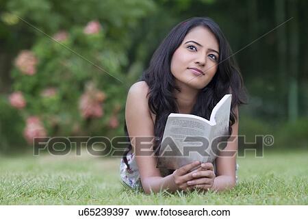 Young woman with a book thinking View Large Photo Image Stock Photo - Young woman with a book thinking . Fotosearch