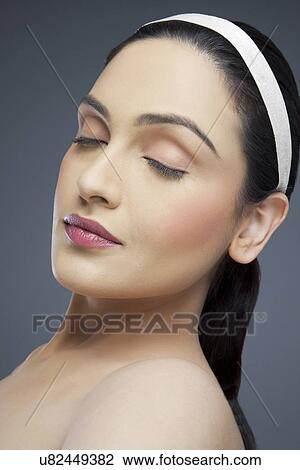 Young woman with eyes closed over colored background View Large Photo Image Stock Image - Young woman with eyes closed over colored background . Fotosearch