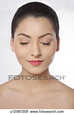 Stock Photo - Young woman with eyes closed over white background . Fotosearch